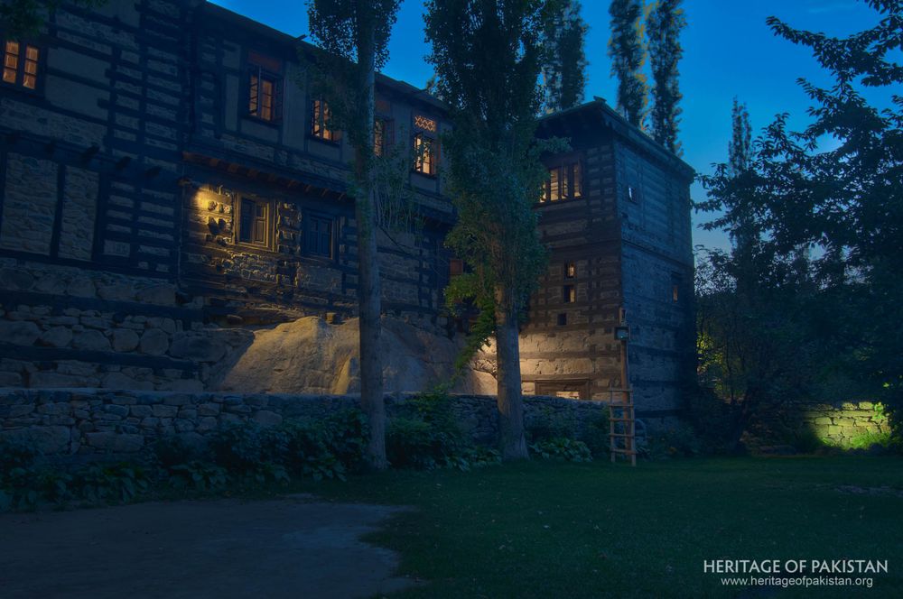 Shigar Fort glows warmly as twilight falls on its timber-framed walls.